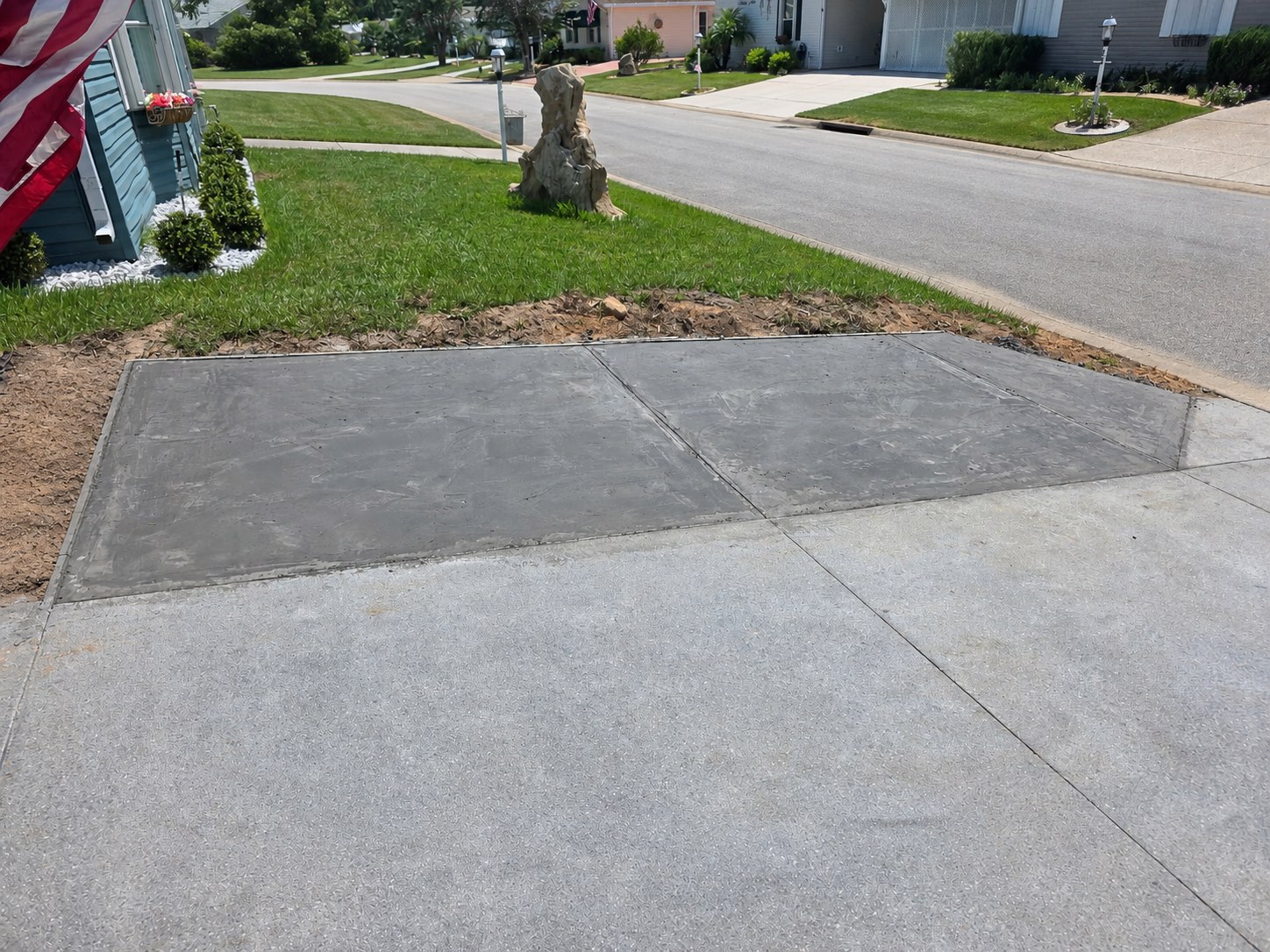 Completed concrete driveway widening connected to the existing driveway