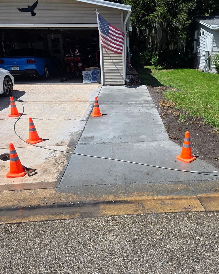 Fresh concrete side driveway pad tied into the existing paver driveway