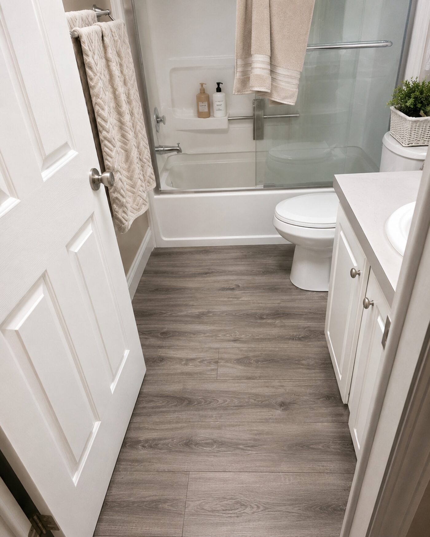 Luxury vinyl plank flooring in a bathroom with a tub and vanity