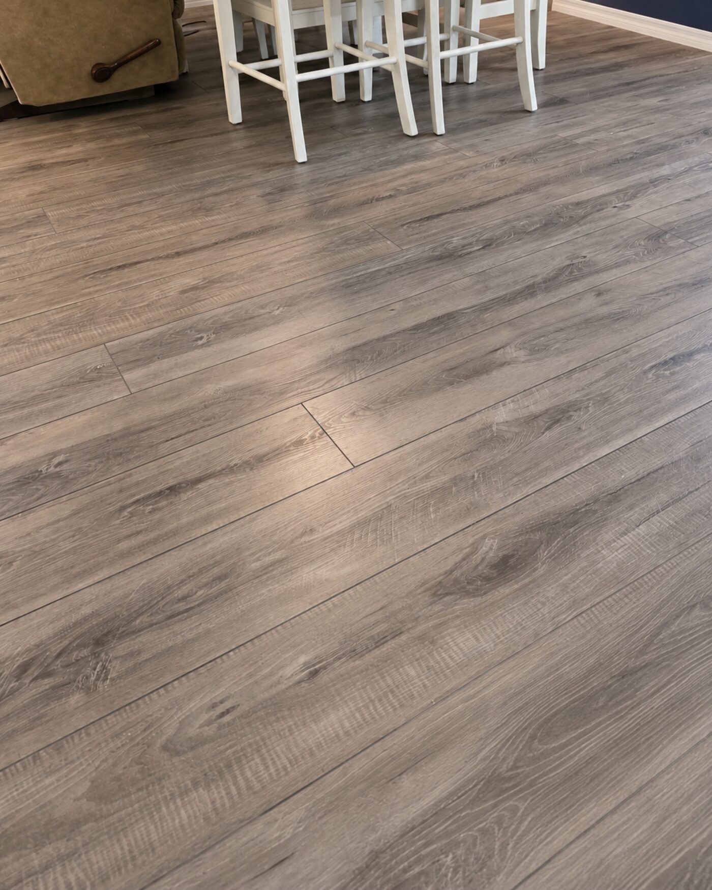 Close-up of luxury vinyl plank flooring in a dining area showing the wood-grain texture