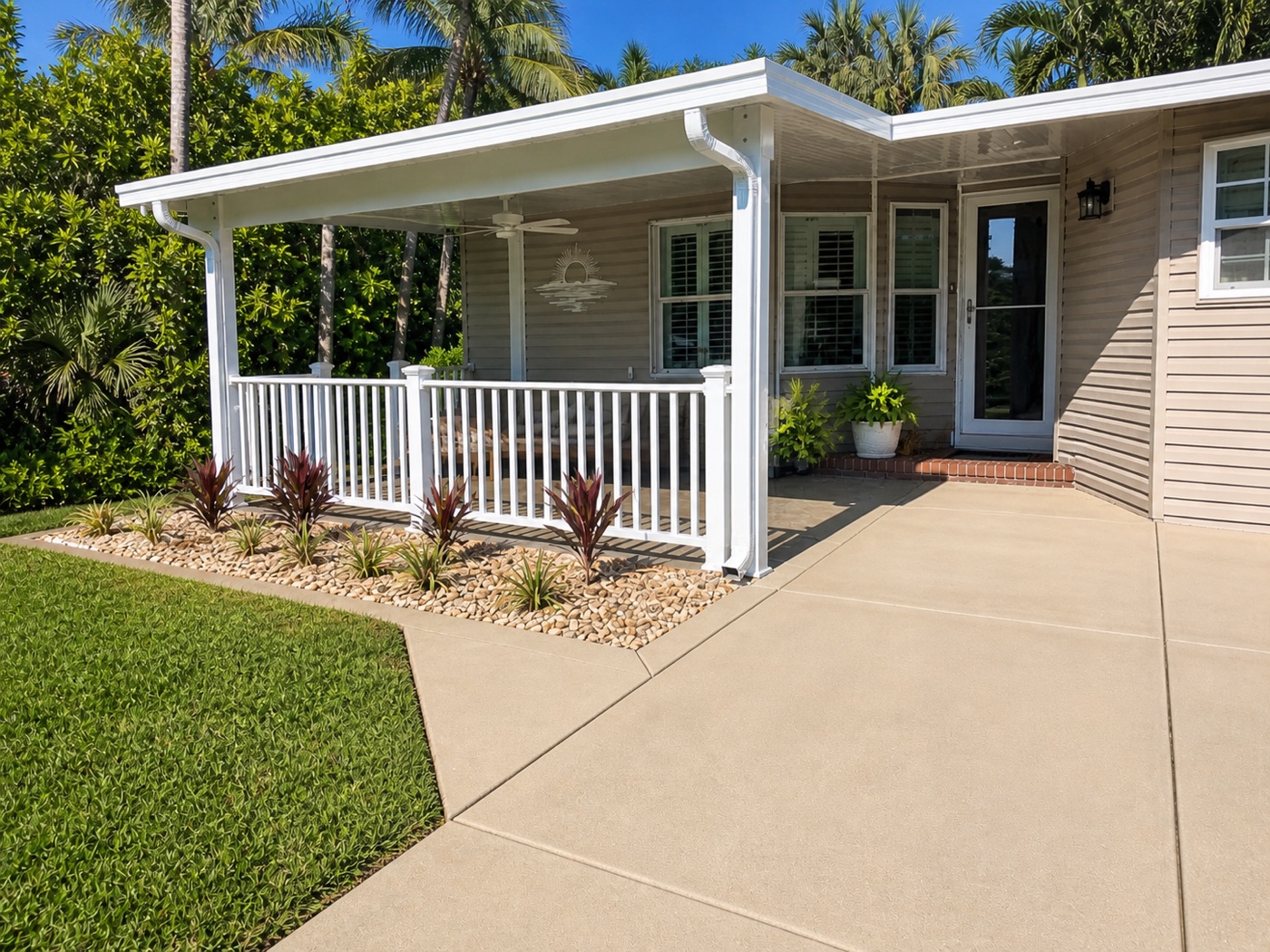 Open front porch with white railings, palm landscaping, and concrete patio
