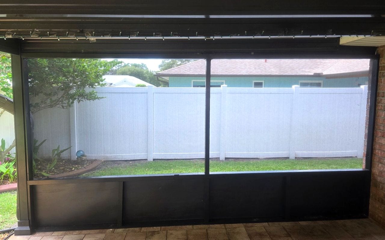 Screened lanai panel work facing a backyard and privacy fence